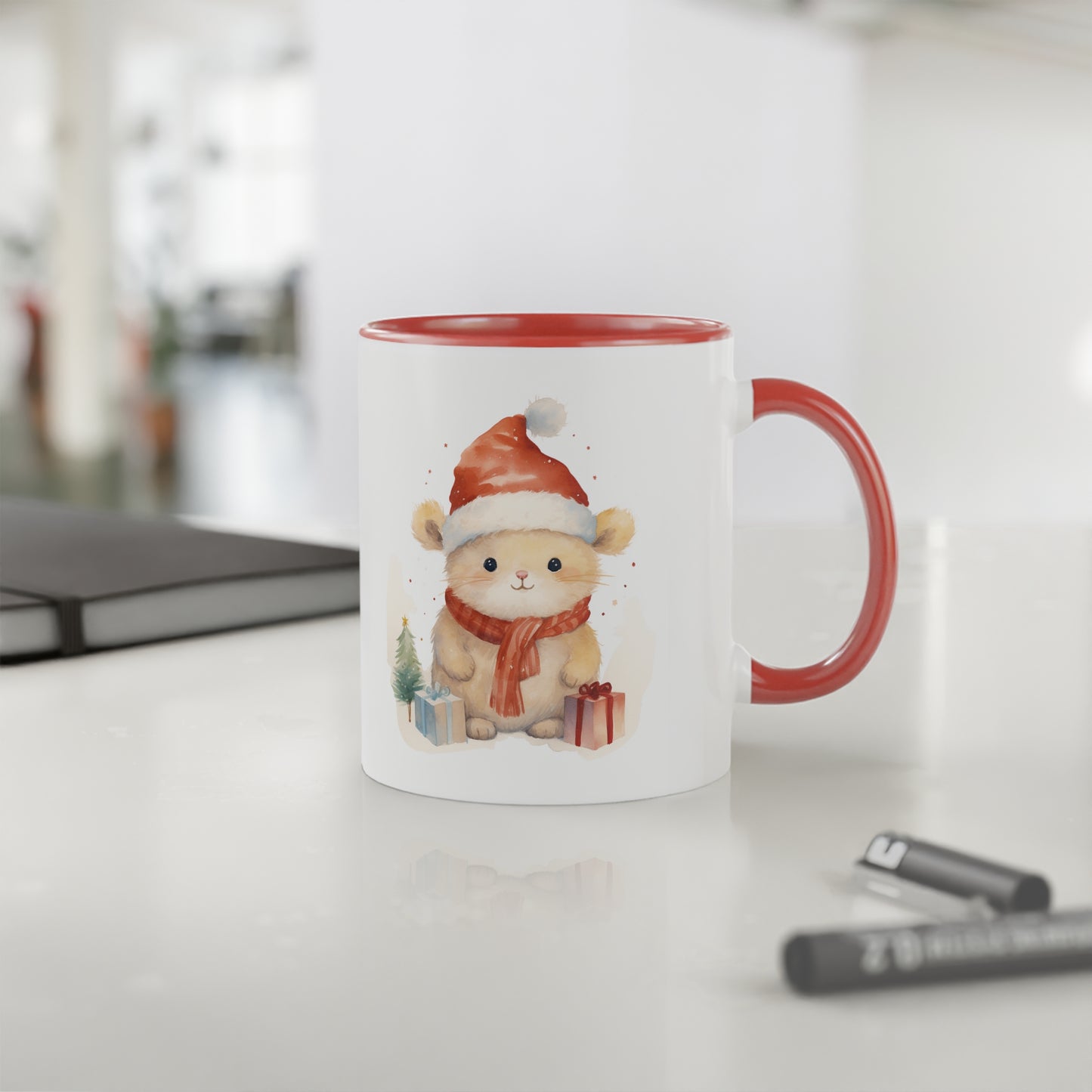 Close up image of a white ceramic mug with red handle and inner side, picture of a Christmas mouse and presents, counter top view